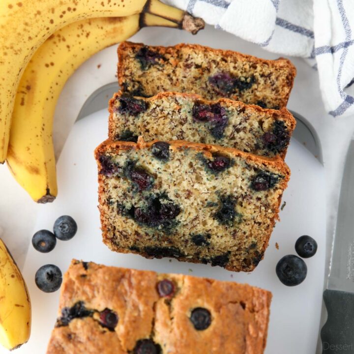 Blueberry banana bread with sour cream sliced on cutting board.