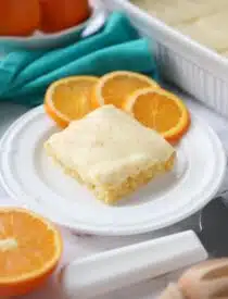 Orange Brownies on a plate with slices of oranges.