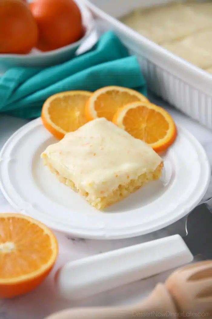 Orange Brownies on a plate with slices of oranges.