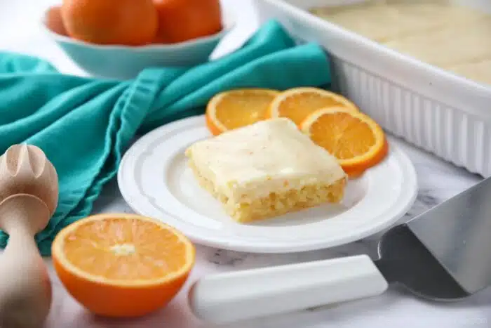 Orange Brownies on a plate with slices of oranges.