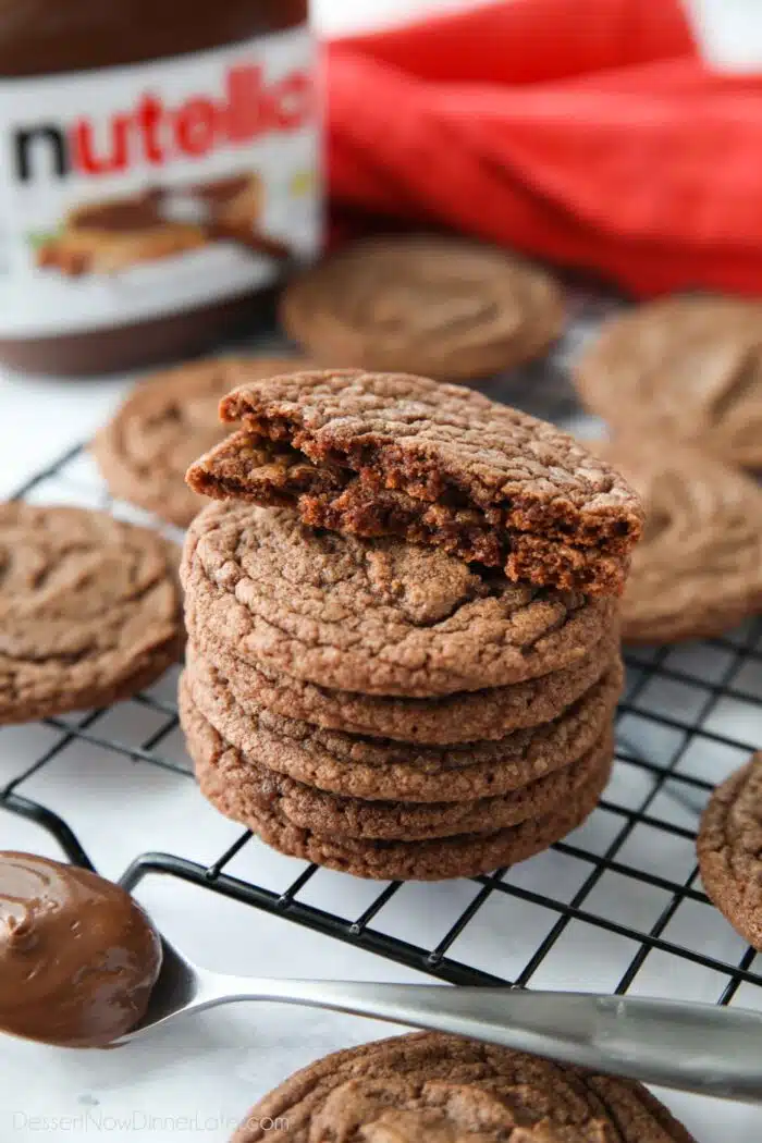 A cookie broken in half and stacked on top of more Nutella Cookies.