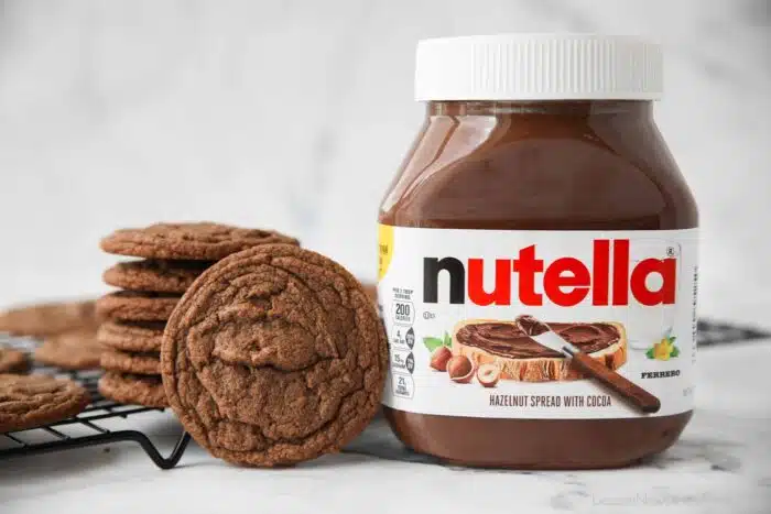 Jar of Nutella next to some cookies.