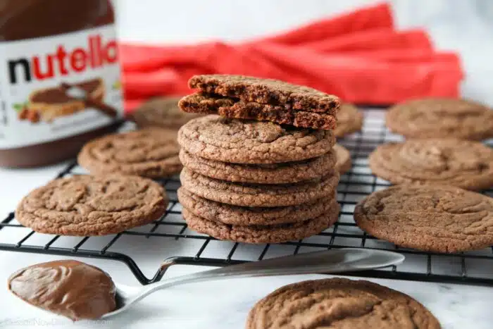 A cookie broken in half and stacked on top of more Nutella Cookies.