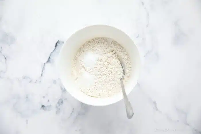 Dry ingredients in a bowl with a spoon.