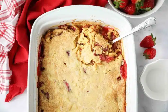 Pan of strawberry dump cake with spoon inside.