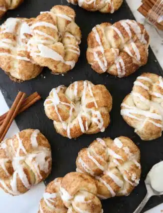 Iced cinnamon knots on a slate board.