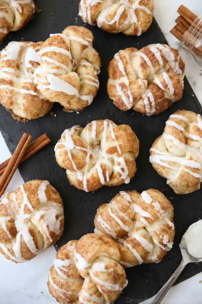 Iced cinnamon knots on a slate board.