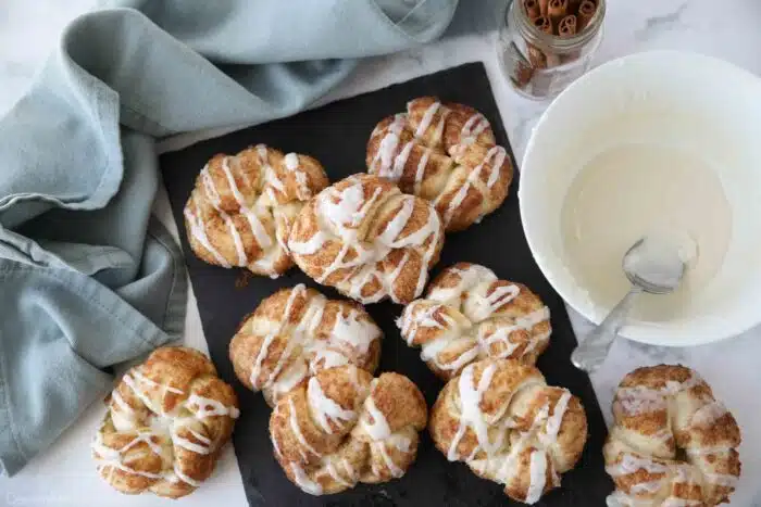 Cinnamon knots on a slate board with icing.