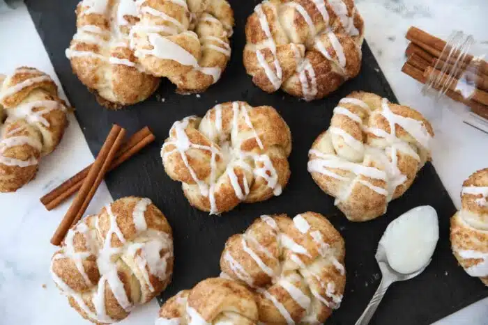 Glazed cinnamon knots on a slate board.