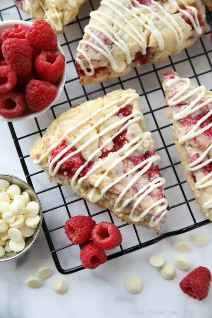 White chocolate raspberry scones on a wire cooling rack.