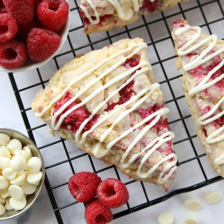 White chocolate raspberry scones on a wire cooling rack.