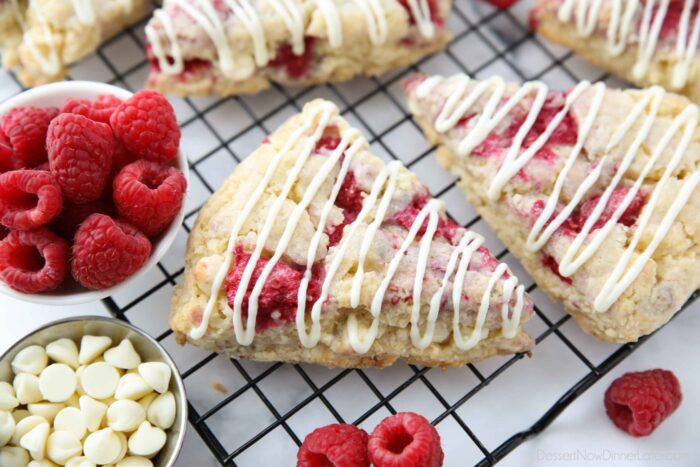 Close up of raspberry scones with white chocolate drizzled on top.