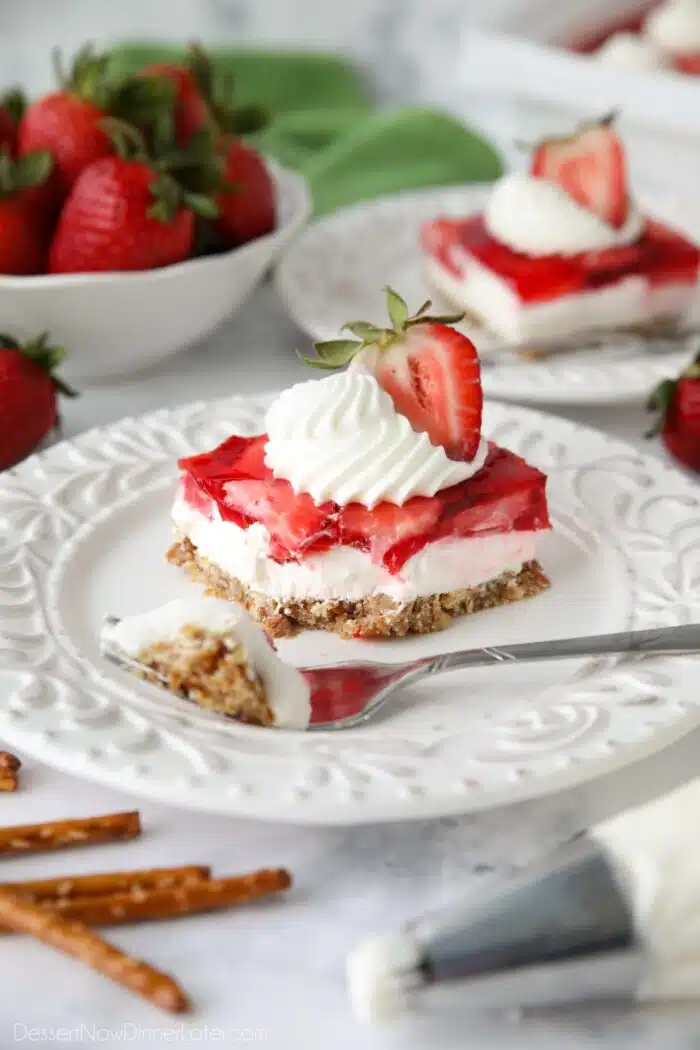 Fork full removed of a piece of strawberry pretzel salad dessert.