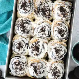 Pan of frosted Oreo cinnamon rolls with cream cheese frosting.