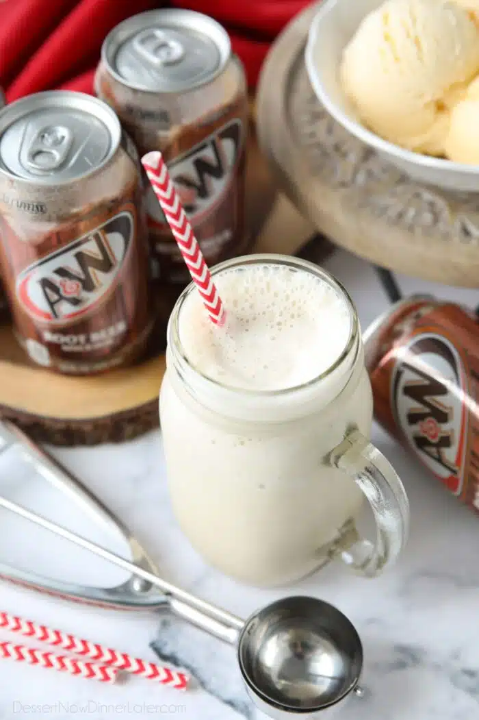 Mason jar mug full of root beer milkshake and a straw.