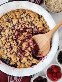 Spooning berry crisp (aka berry crumble) out of dish.