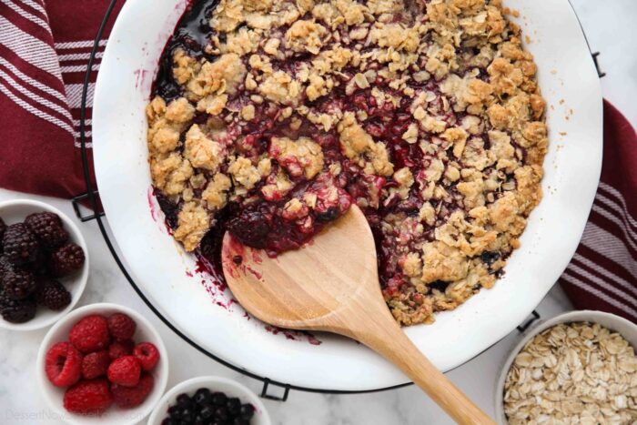 Spooning berry crisp (aka berry crumble) out of dish.