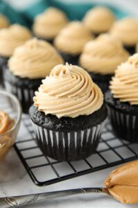Peanut butter frosting piped on top of a chocolate cupcake.