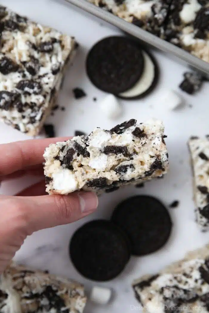 Holding a rice krispie treat with Oreos.