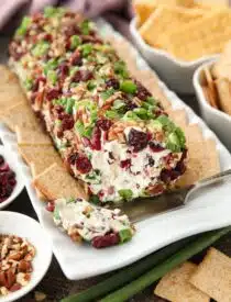 Cranberry Pecan Cheeseball shaped into a log with the inside showing.