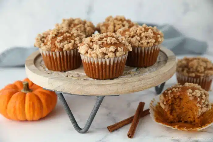 Pumpkin streusel muffins with crumb topping on a cake stand.