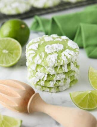 Stack of lime crinkle cookies with powdered sugar.