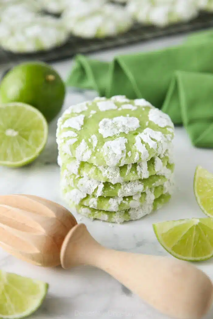 Stack of lime crinkle cookies with powdered sugar.