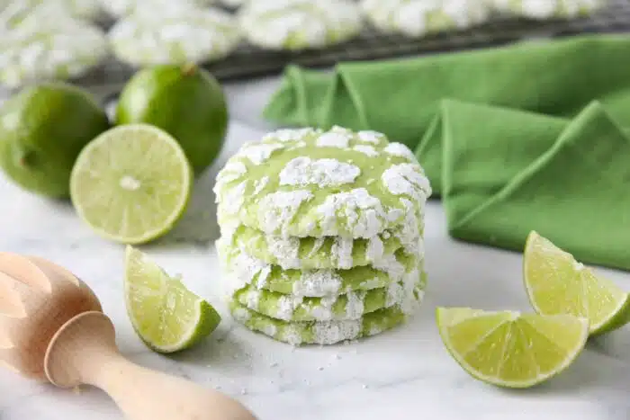 Stack of lime crinkle cookies with powdered sugar.