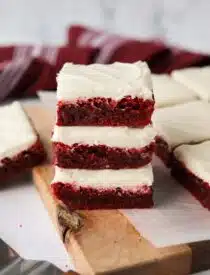 Stack of three Red Velvet Brownies with cream cheese frosting.