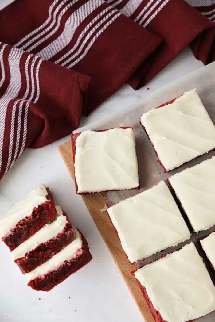 Squares of Red Velvet Brownies with cream cheese frosting on top.