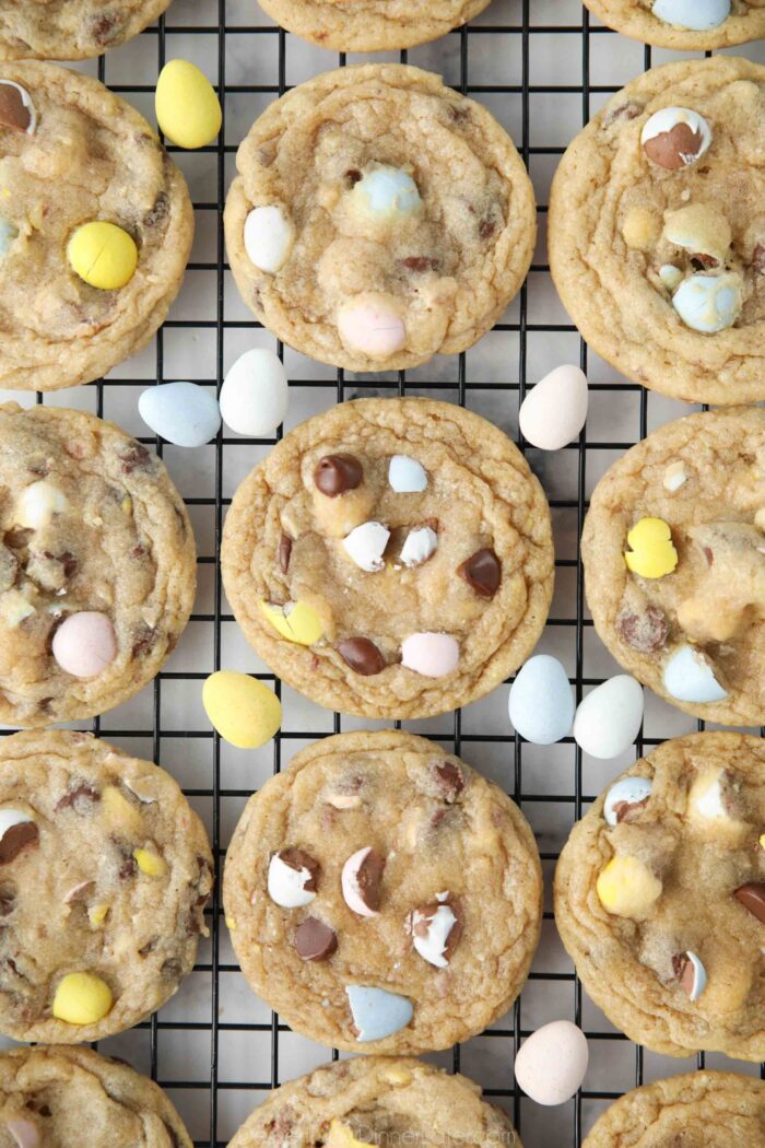 Chocolate chip Easter cookies with Cadbury mini eggs on a cooling rack.