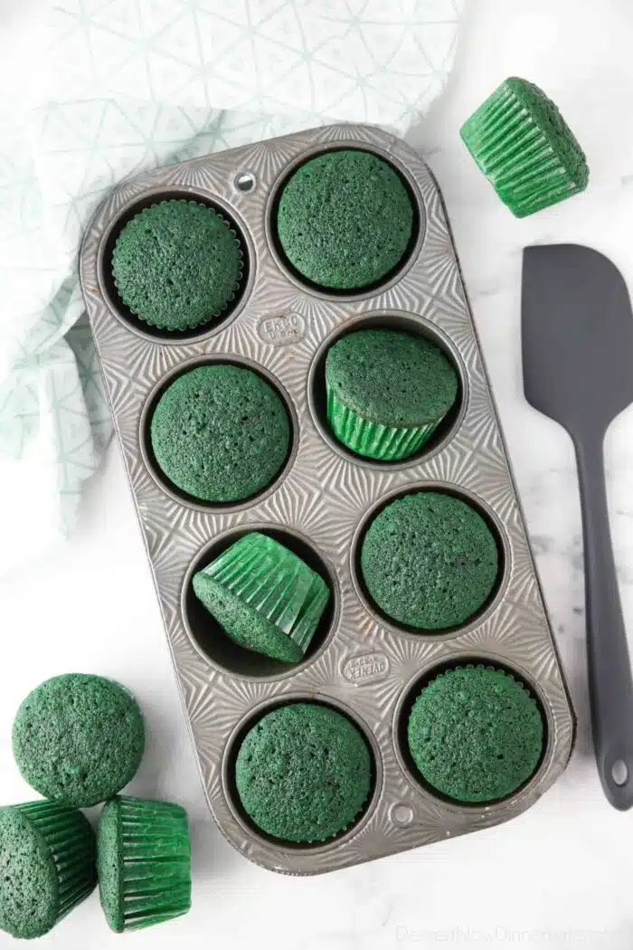 Baked green cupcakes in pan.