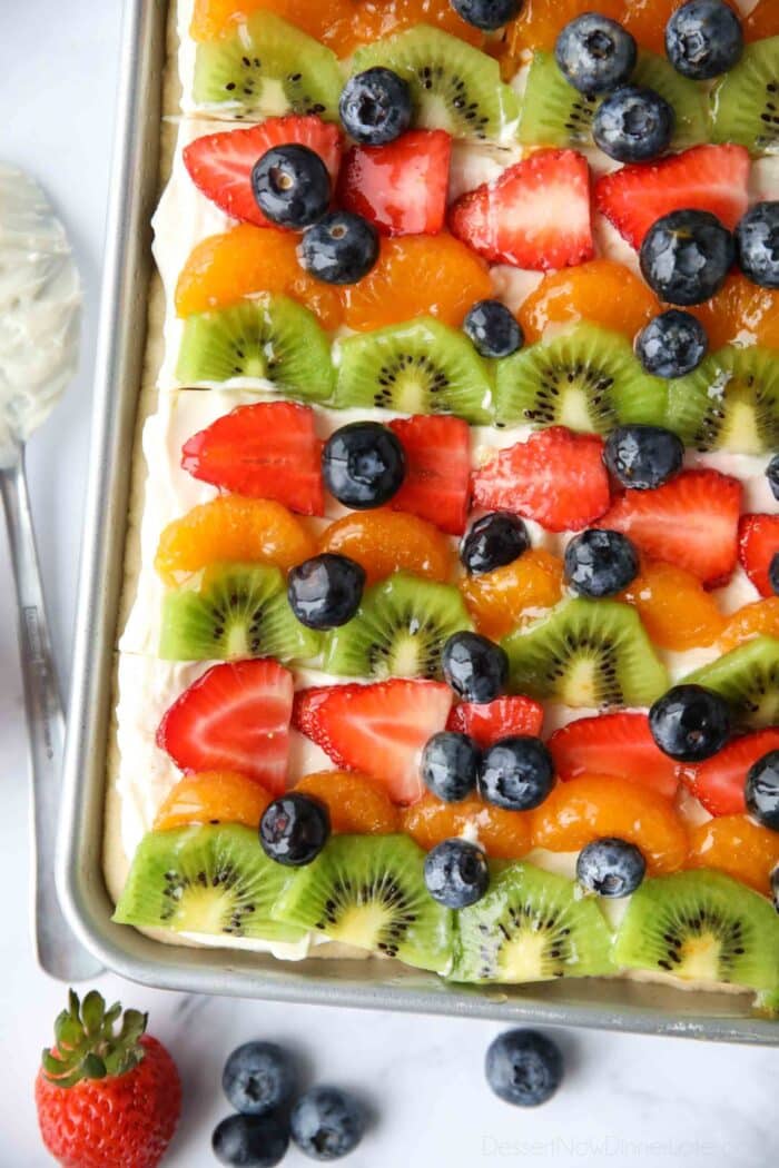 Top view of sugar cookie fruit pizza bars with cream cheese frosting.