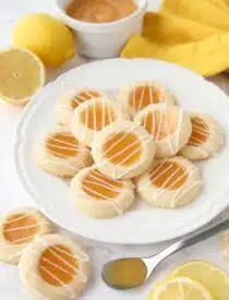 Plate of lemon curd cookies with glaze drizzled on top.