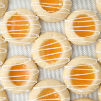 Shortbread cookies with lemon curd in the center and a powdered sugar glaze drizzled on top.