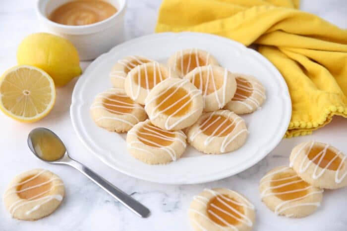 Plate of lemon curd cookies with glaze drizzled on top.