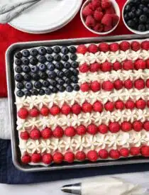 4th of July Fruit Pizza made with a brownie base and decorated with whipped cream cheese frosting, blueberries and raspberries for the stars and stripes.