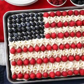 4th of July Fruit Pizza made with a brownie base and decorated with whipped cream cheese frosting, blueberries and raspberries for the stars and stripes.