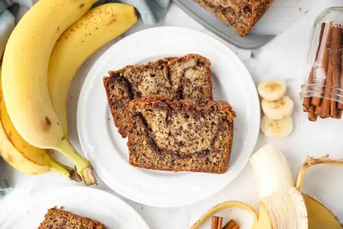 Two pieces of cinnamon swirl banana bread on a plate.