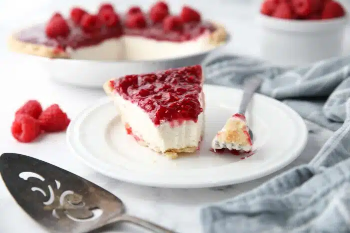 Slice of Raspberry Cream Pie on a plate with a forkful taken out.