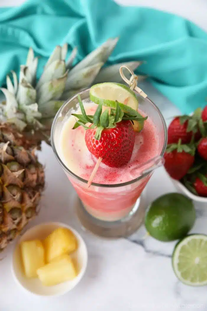 Top view of Virgin Miami Vice Drink in a tall glass with a strawberry and lime garnish.