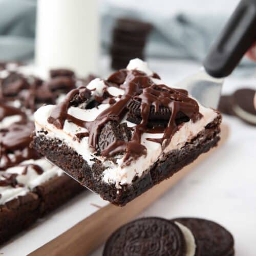 Scooping up a cookies and cream brownie with a spatula.