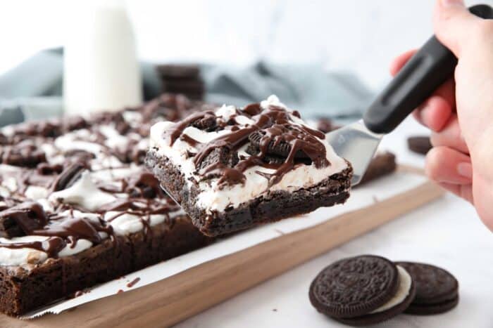Scooping up a cookies and cream brownie with a spatula.