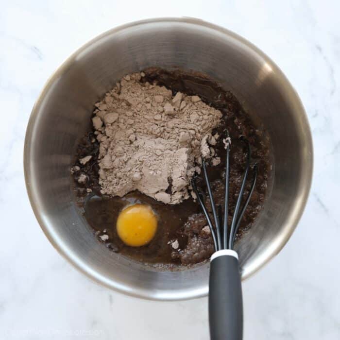 Brownie ingredients in a bowl with a whisk.