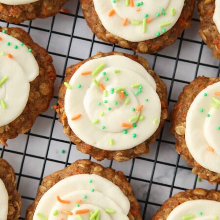 Top view of carrot cake cookies with cream cheese frosting swirled on top.
