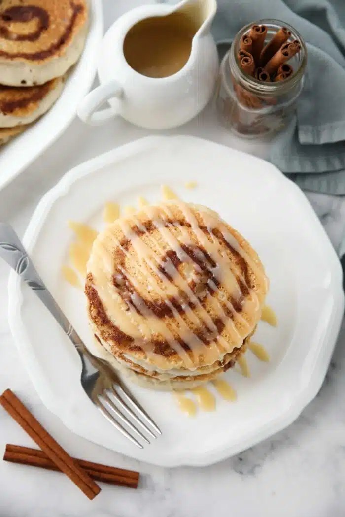 Top view of cinnamon roll pancakes with cream cheese glaze drizzled on top.