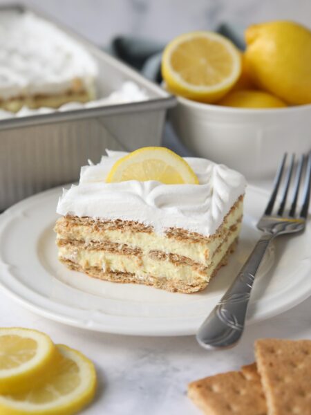 Slice of lemon icebox cake layered with graham crackers, pudding, and whipped topping.