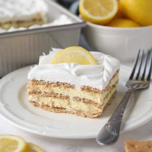 Slice of lemon icebox cake layered with graham crackers, pudding, and whipped topping.