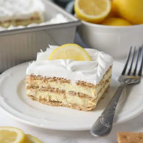 Slice of lemon icebox cake layered with graham crackers, pudding, and whipped topping.