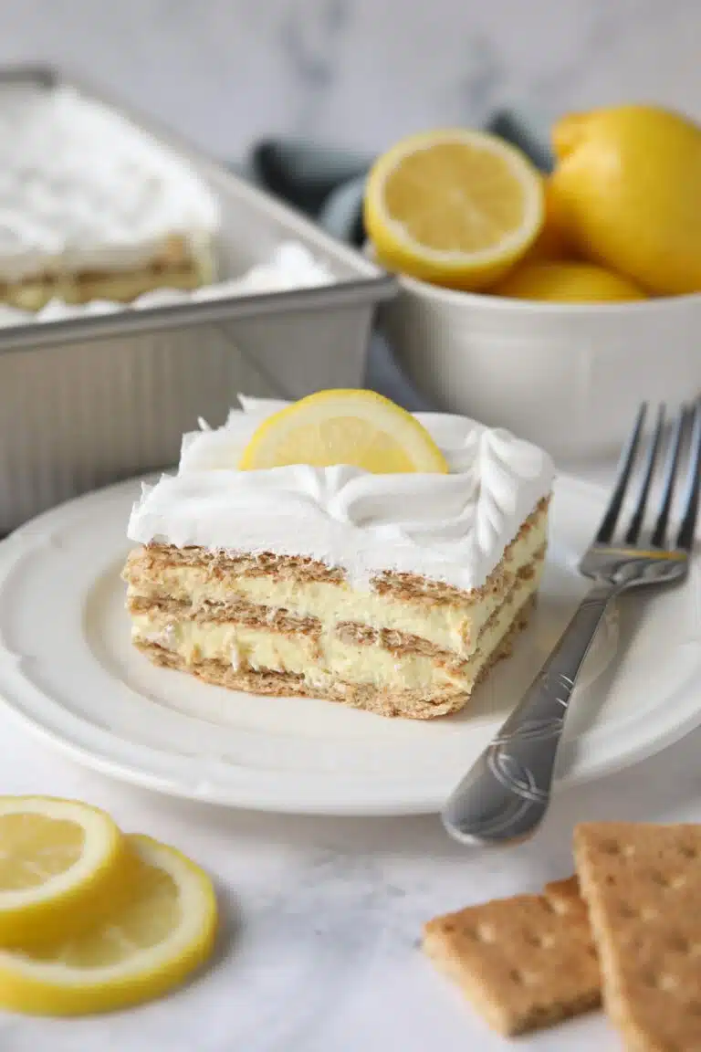 Slice of lemon icebox cake layered with graham crackers, pudding, and whipped topping.